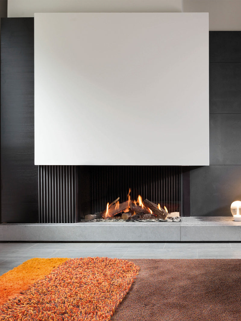 Corner view of Kalfire GP110/55C gas fire with glass front, showcasing flames and sleek design in a modern setting.
