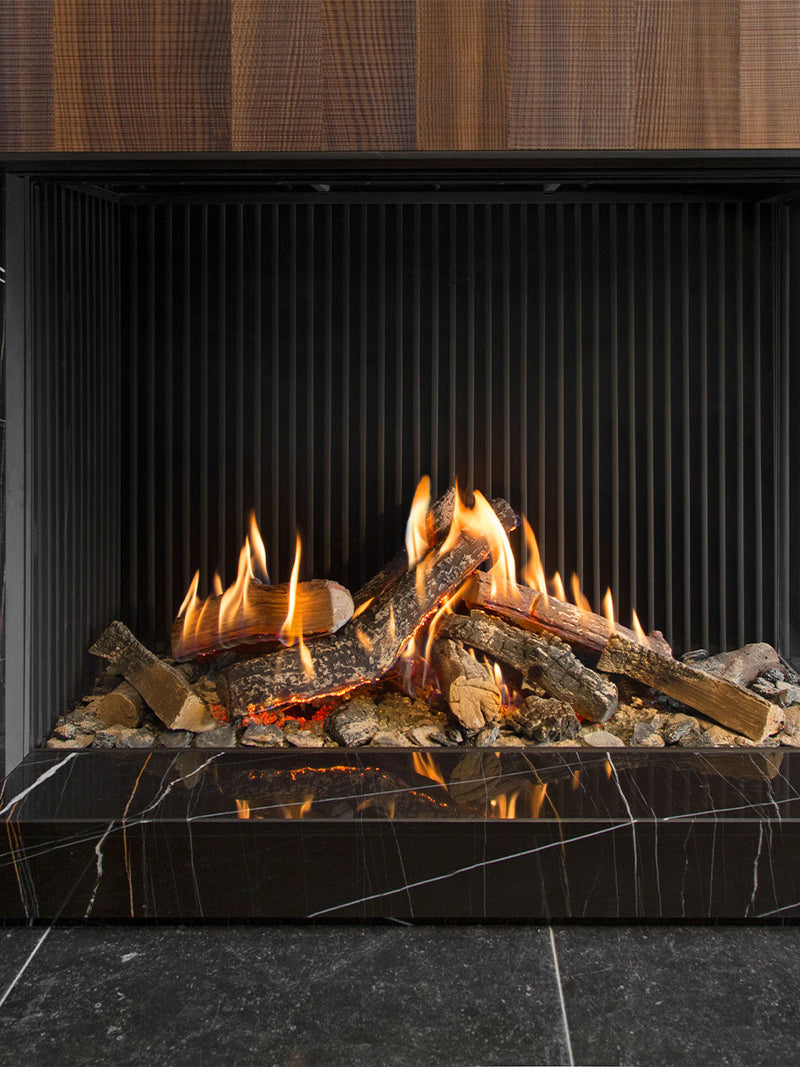 Side view of Kalfire GP110/75C gas fire in black, showcasing flames through tall glass in a modern corner setting.