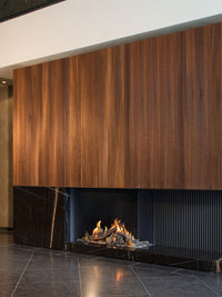 Corner view of Kalfire GP110/75C gas fire with tall glass window showcasing flames in a modern living space.