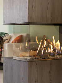 Side view of Kalfire GP115/55R gas fire room divider with ceramic logs and glass panel, showcasing modern design.