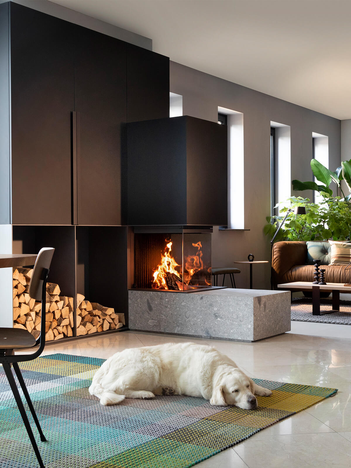 Curved ceramic glass wood burner fireplace in a modern open-plan setting, showcasing its unique room divider design.
