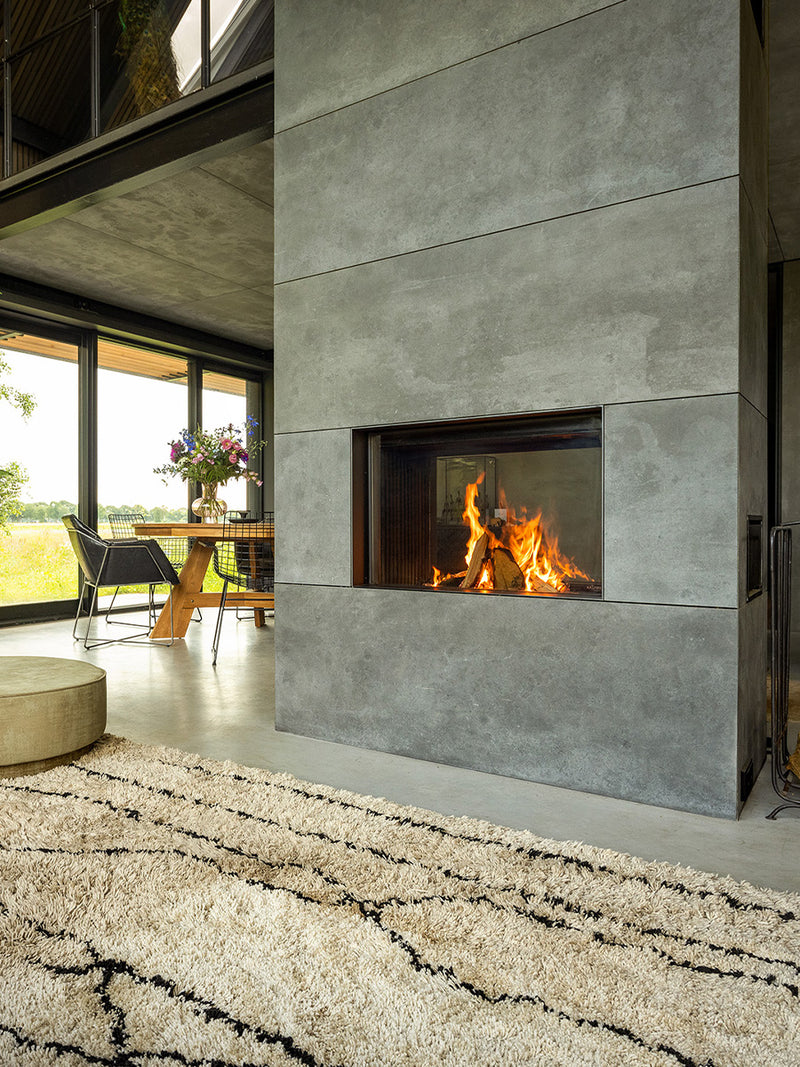 Side view of Kalfire W80/52T tunnel wood burner fireplace with frameless glass and visible flames, showcasing its design.