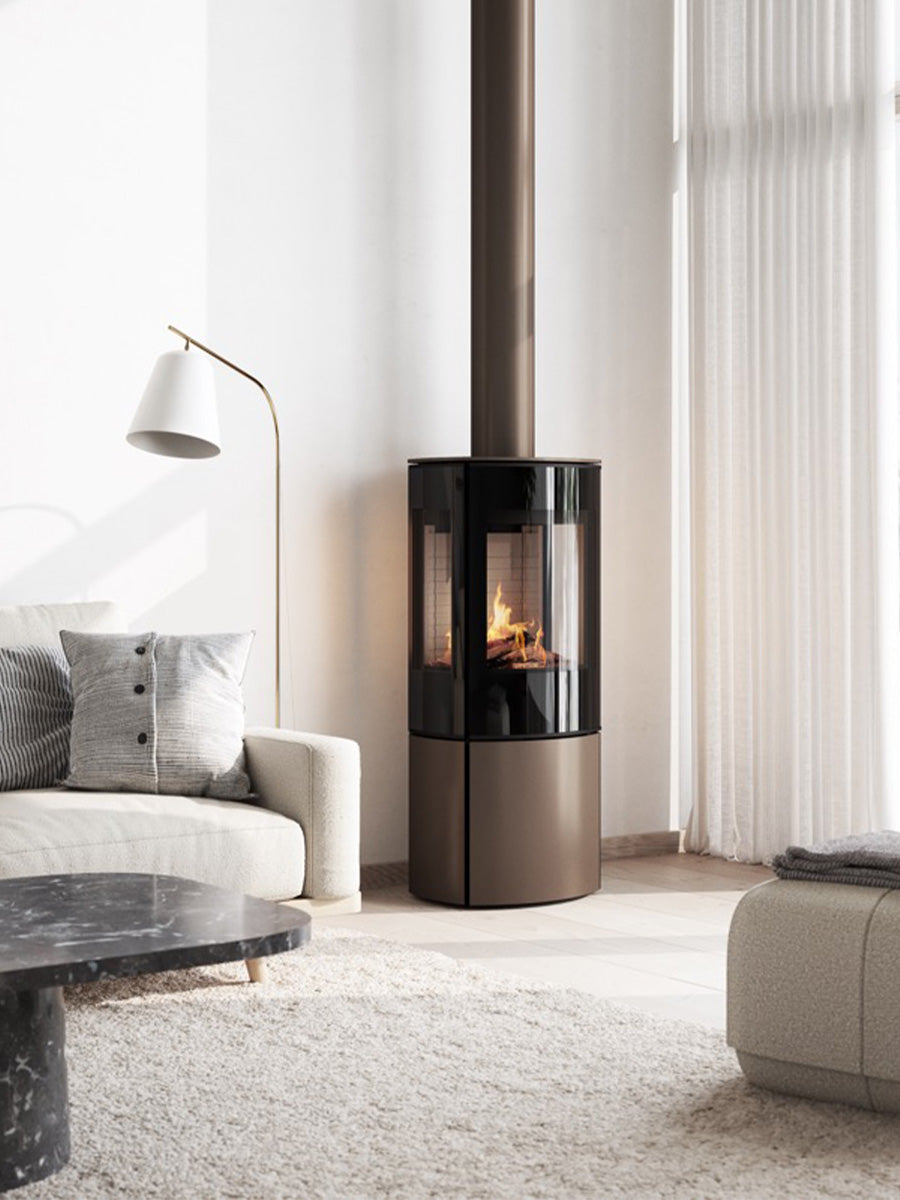 Elegant freestanding RAIS Caro 110 gas fireplace with glass door and side panels showcasing vibrant flames.