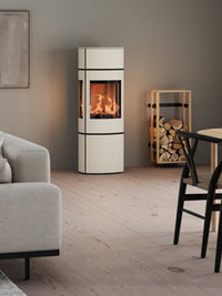 Elegant freestanding RAIS Caro 130 gas fireplace with a glass door and side panels showcasing panoramic flames.