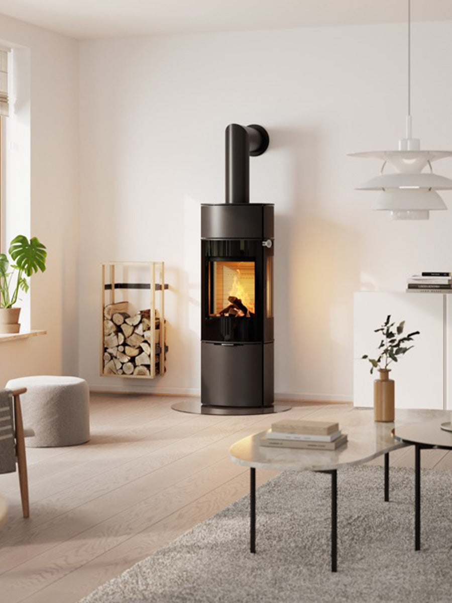 Tall RAIS Caro 130 wood burning stove in black with full glass door, showcasing flames and elegant design.