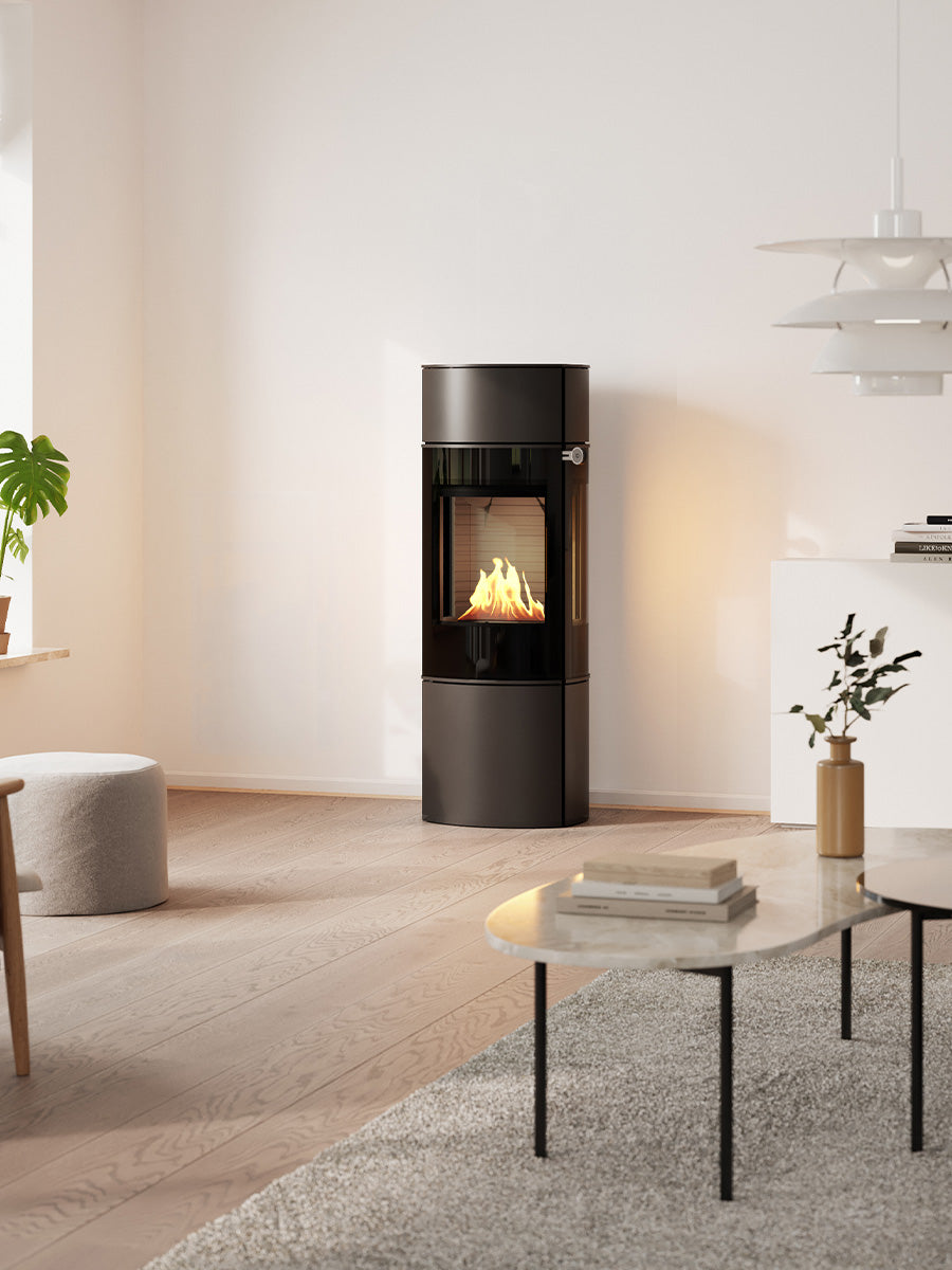 Compact RAIS Caro 130 bioethanol fireplace with glass door, showcasing a sleek rounded design in a modern setting.
