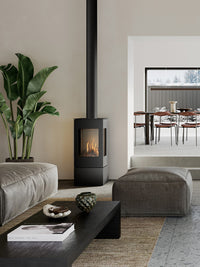 Side view of the RAIS Nexo 100 gas fireplace with a sleek steel door and large glass panes, showcasing its elegant design.