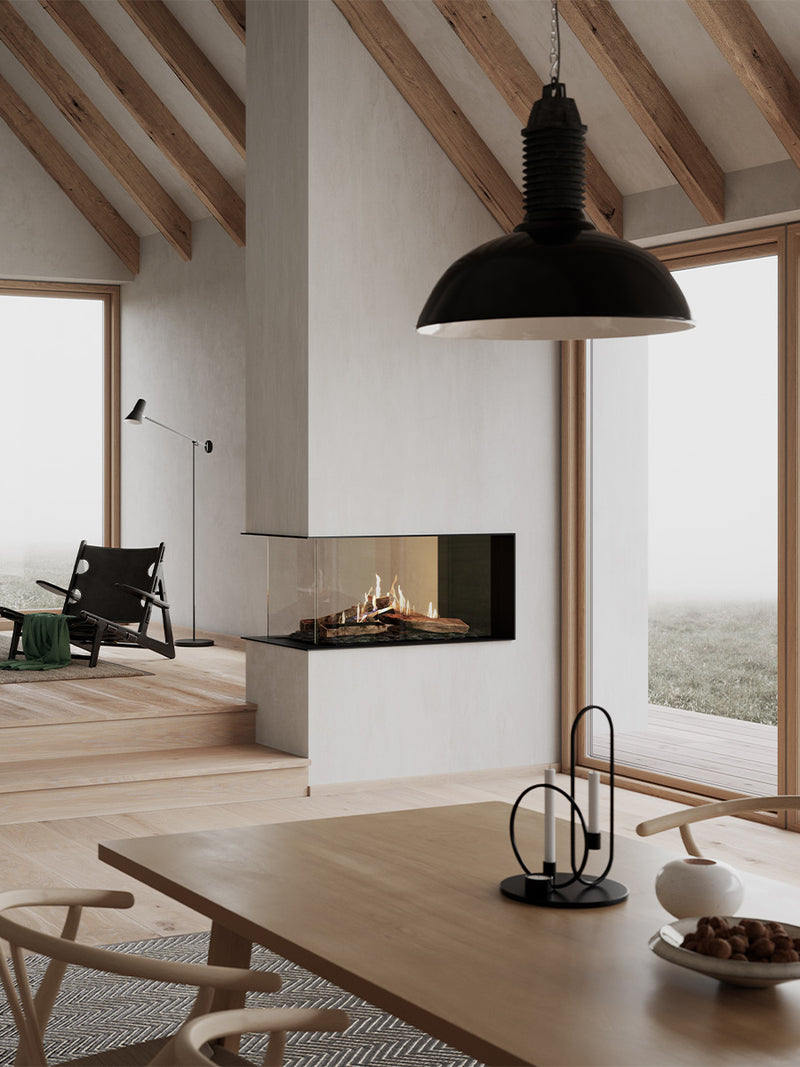 Modern RAIS Visio 100 RD gas fireplace insert with three glass sides, showcasing flames, used as a stylish room divider.