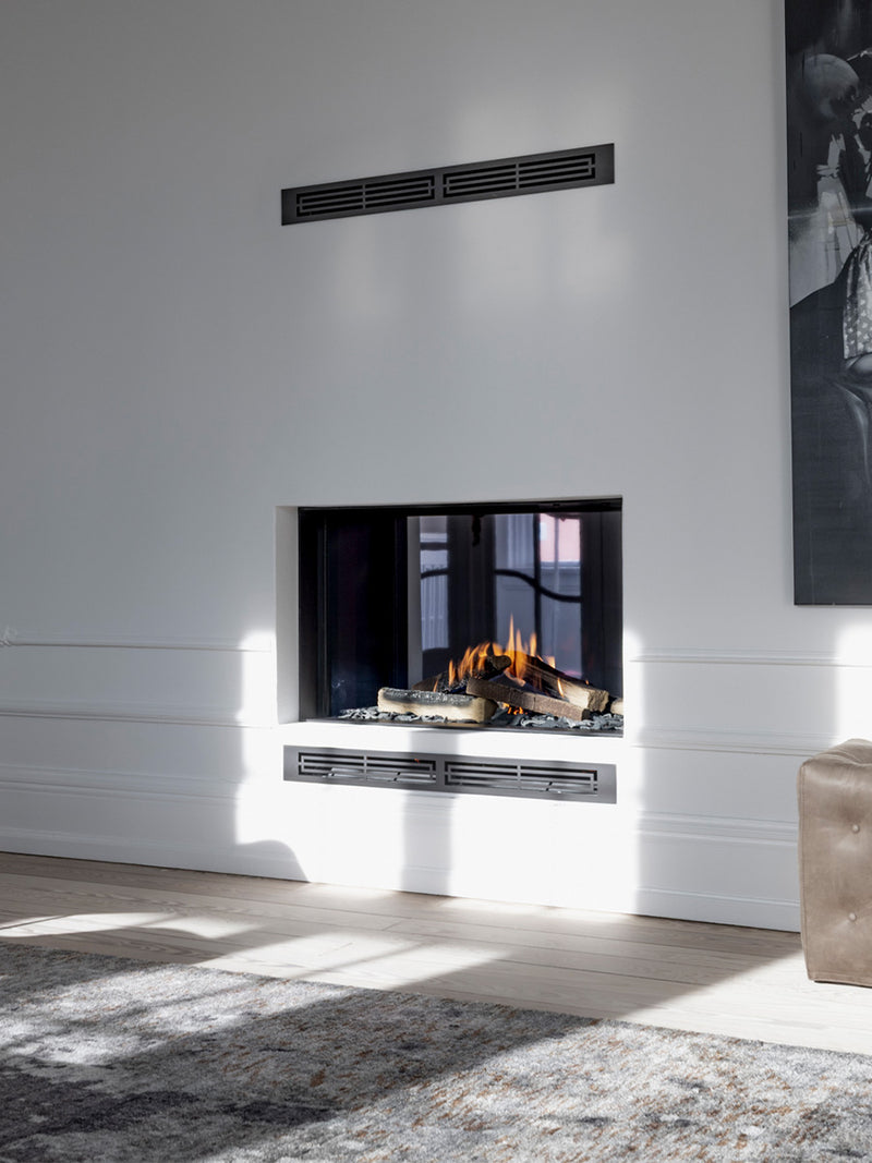 Side view of RAIS Visio 100 T gas fireplace insert tunnel with black frame, showcasing flames visible from both rooms.