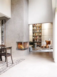 Side view of RAIS Visio 2 wood burning stove with large glass panes, showcasing elegant corner design and discreet framing.