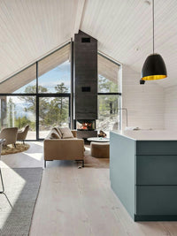 Side view of RAIS Visio 3 wood burning stove showcasing three glass sides and sleek design in a modern setting.