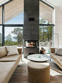Three-sided RAIS Visio 3 wood burning stove with glass panels, showcasing a sleek design in a modern living space.