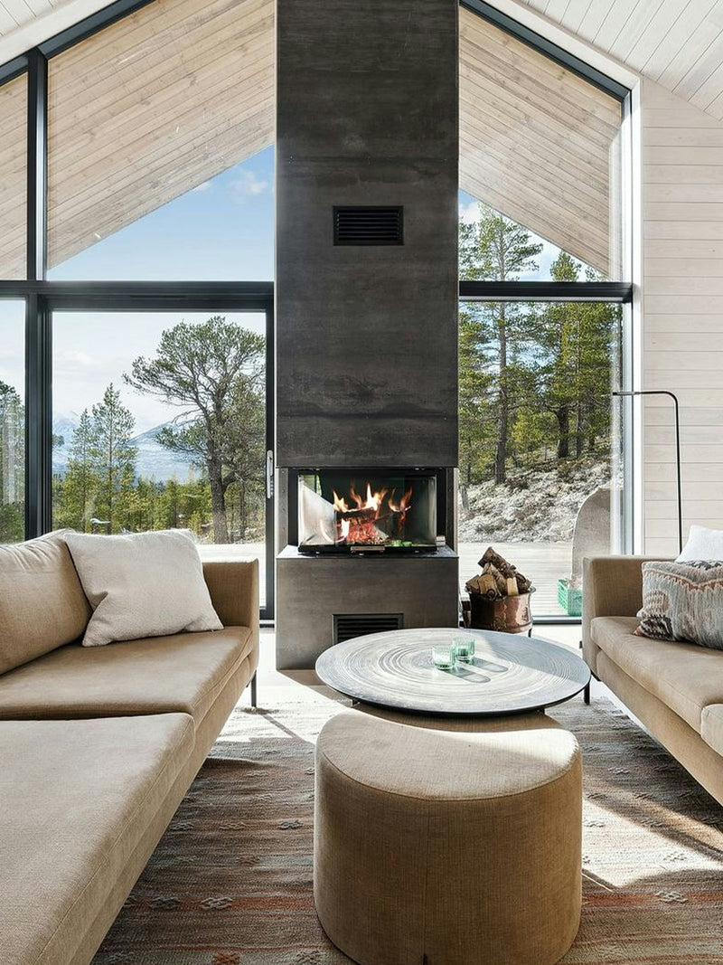 Three-sided RAIS Visio 3 wood burning stove with glass panels, showcasing a sleek design in a modern living space.