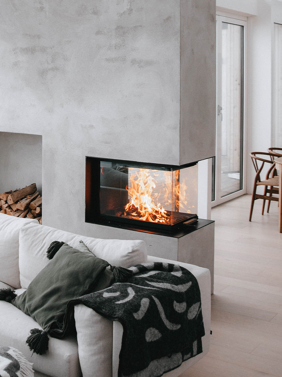 RAIS Visio 3:1 inset wood burning stove room divider with glass on three sides, showcasing flickering flames and elegant design.
