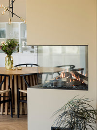 Side view of RAIS Visio 70 RD gas fireplace insert room divider with black finish and two glass fronts showcasing the fire.