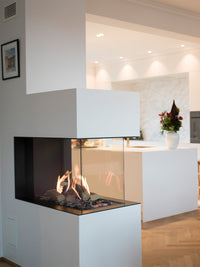 Side view of RAIS Visio 90 RD gas fireplace insert with black frame, showcasing flames through three large glass panels.
