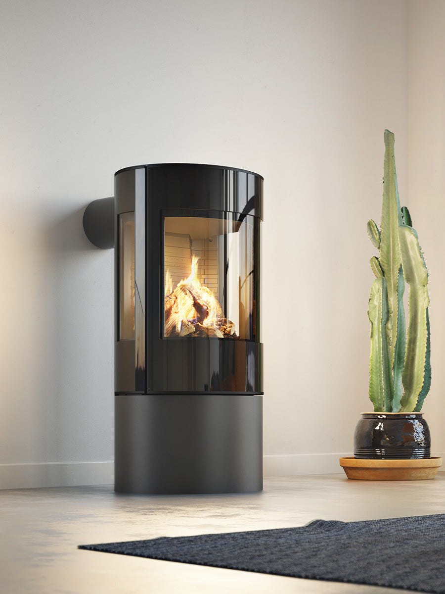 Round RAIS Viva L 100 gas fire stove with a glass door, showcasing steady flames and elegant design in a modern setting.