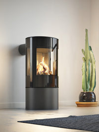 Round RAIS Viva L 100 gas fire stove with a glass door, showcasing steady flames and elegant design in a modern setting.