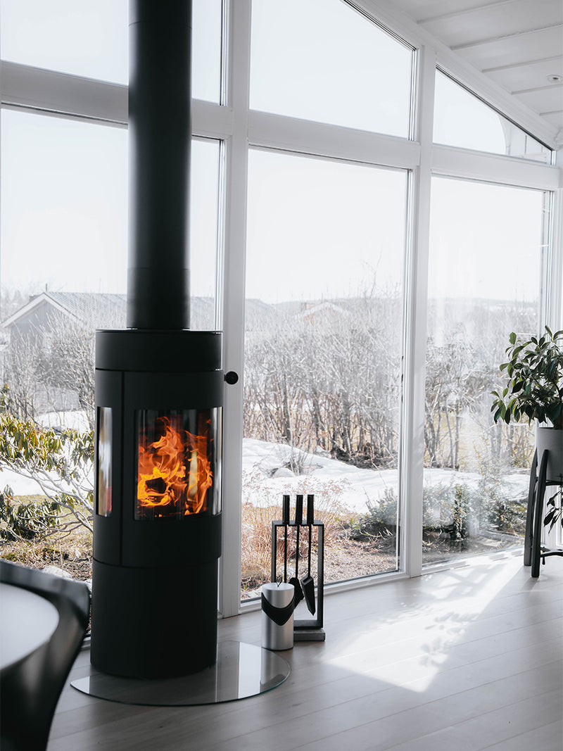 Side view of the RAIS Viva L 120 wood burning stove with a glass door, showcasing its sleek design and curved glass.