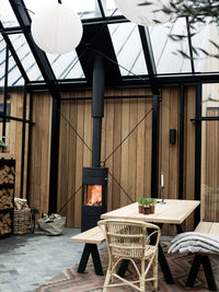 Round RAIS Viva L 120 wood burning stove with large glass door, showcasing curved design and 360° swivel base.