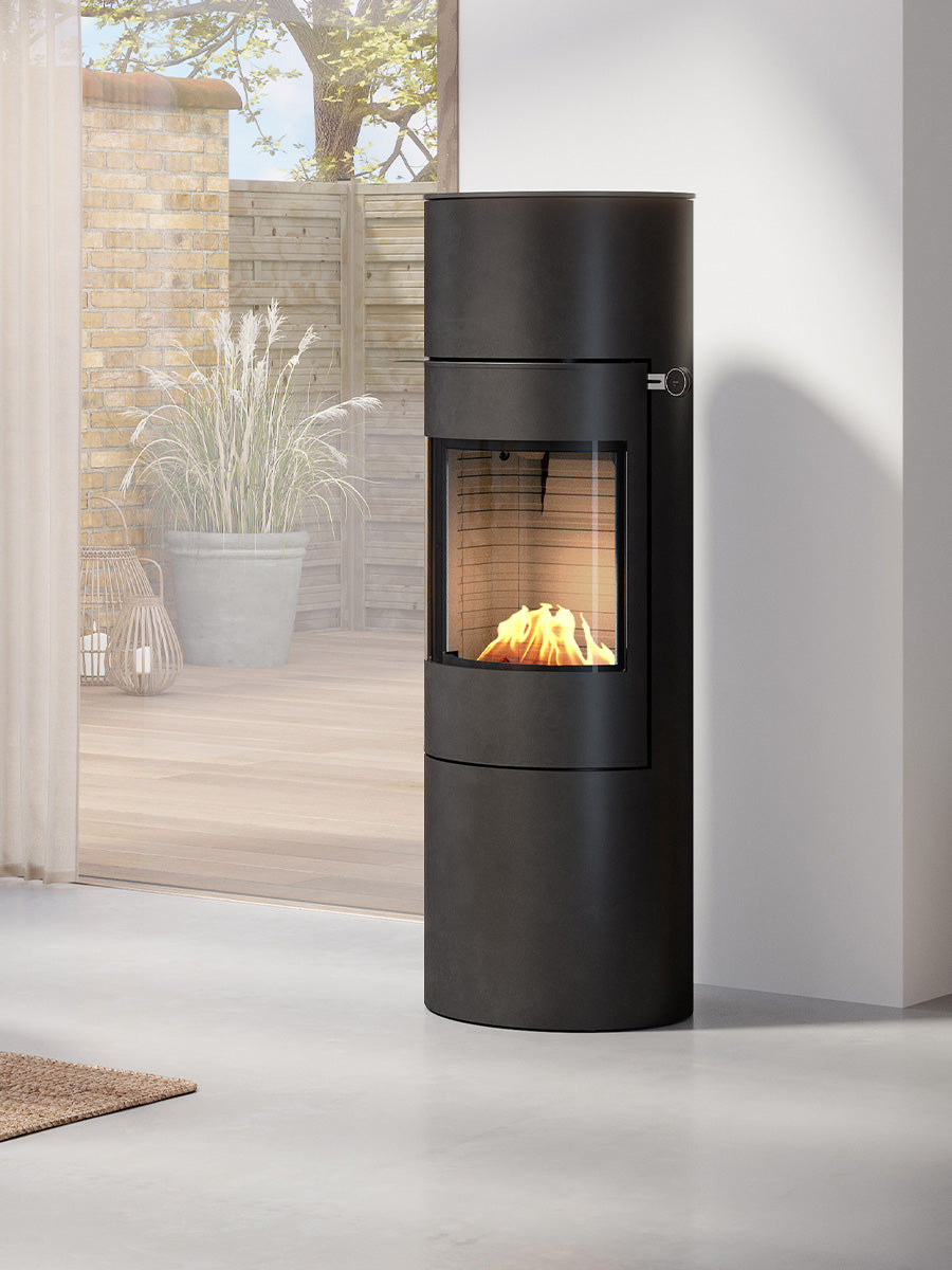 Round RAIS Viva L 140 bioethanol fireplace stove with glass door, sleek black design, positioned in a modern living space.