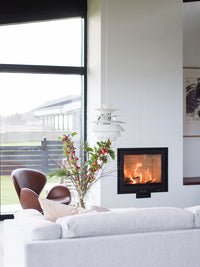 Front view of Rais 600 1 inset wood burning stove with large glass panes and sleek steel frame.
