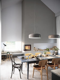 Side view of Rais 600 2 Inset Wood Burning Stove in a corner, showcasing large glass panes and sleek design.