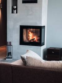 Side view of Rais 600 2 Inset Wood Burning Stove in black, showcasing large glass panes and corner design.