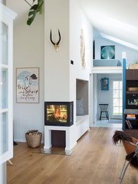 Side view of Rais 600 3 Inset wood burning stove with three glass panes showcasing the flames and elegant cube design.