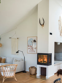 Side view of the Rais 600 3 Inset wood burning stove showcasing three glass panes and sleek cube-shaped design.
