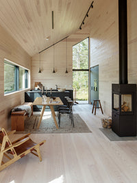 Side view of RAIS 600 Max wood burning stove with a glass door, showcasing its sleek design and modern finish.