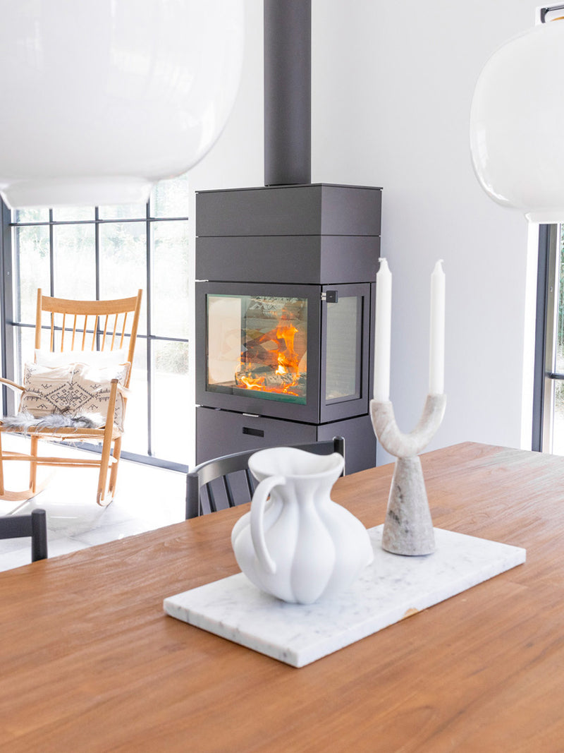 RAIS 600 Max wood burning stove in black with glass door and two storage boxes, viewed from the front.